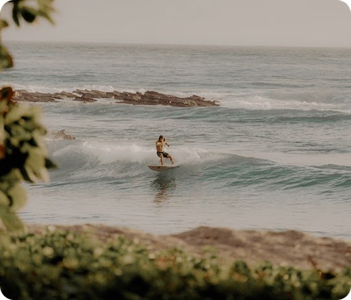 A surfer riding a wave off the tropical coast of Santa Teresa, Costa Rica